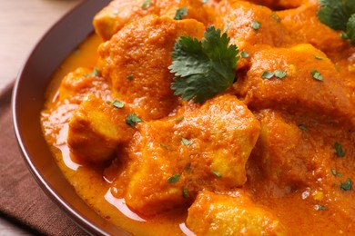 Bowl of delicious chicken curry on table, closeup