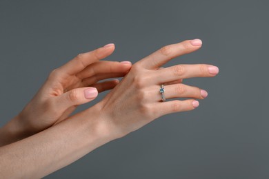 Photo of Woman with elegant ring on dark grey background, closeup