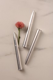 Bullets and beautiful flower on light marble table, flat lay