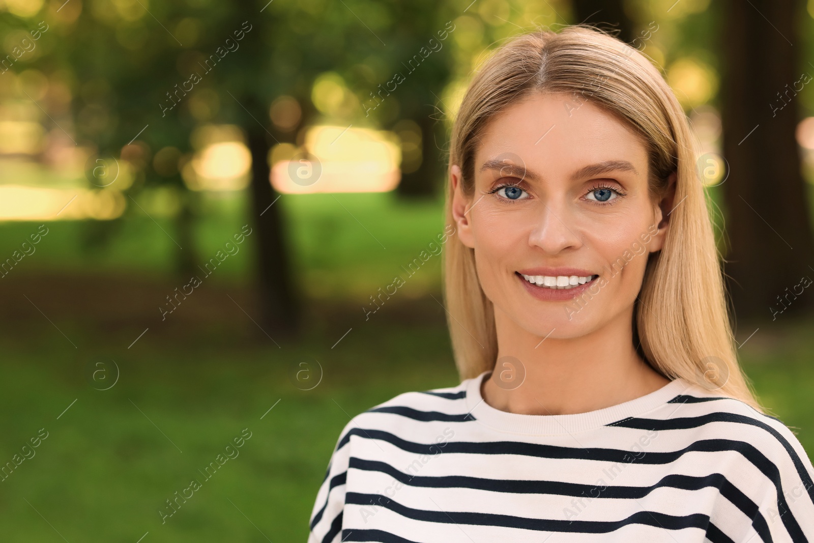 Photo of Portrait of happy woman in casual clothes outdoors. Space for text. Attractive lady smiling and posing for camera