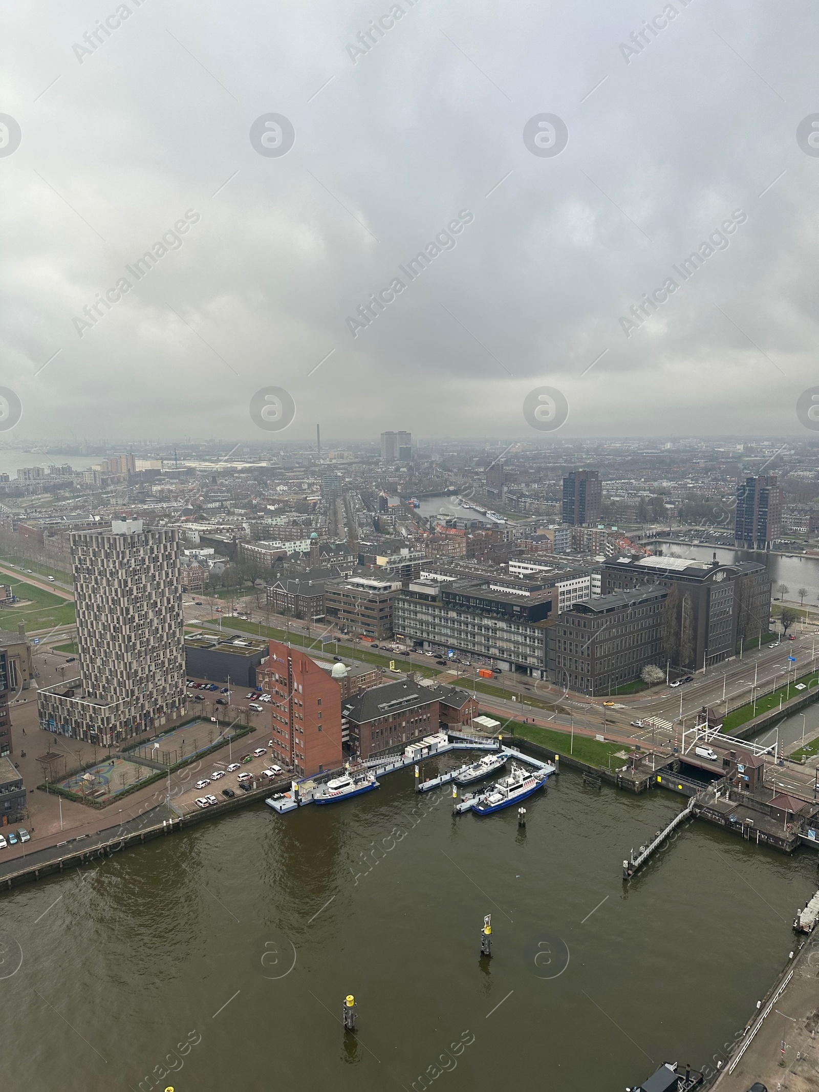 Photo of Picturesque view of city with modern buildings and harbor on cloudy day