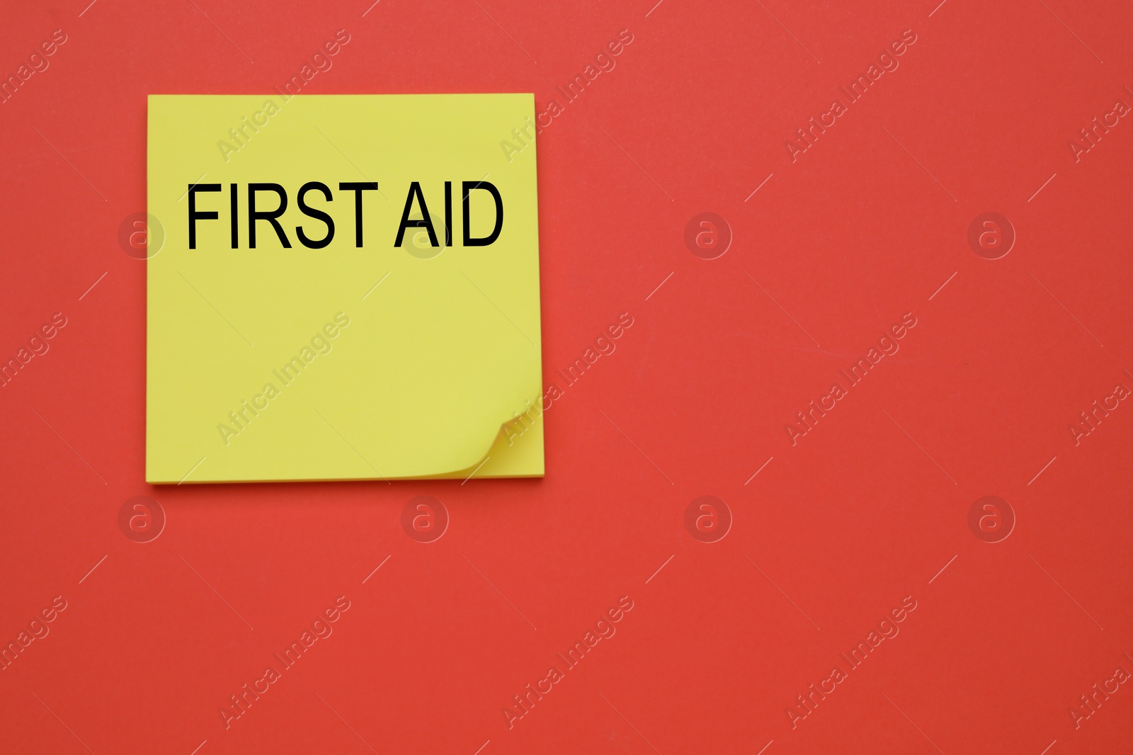 Photo of Yellow paper notes with words First Aid on coral background, top view. Space for text