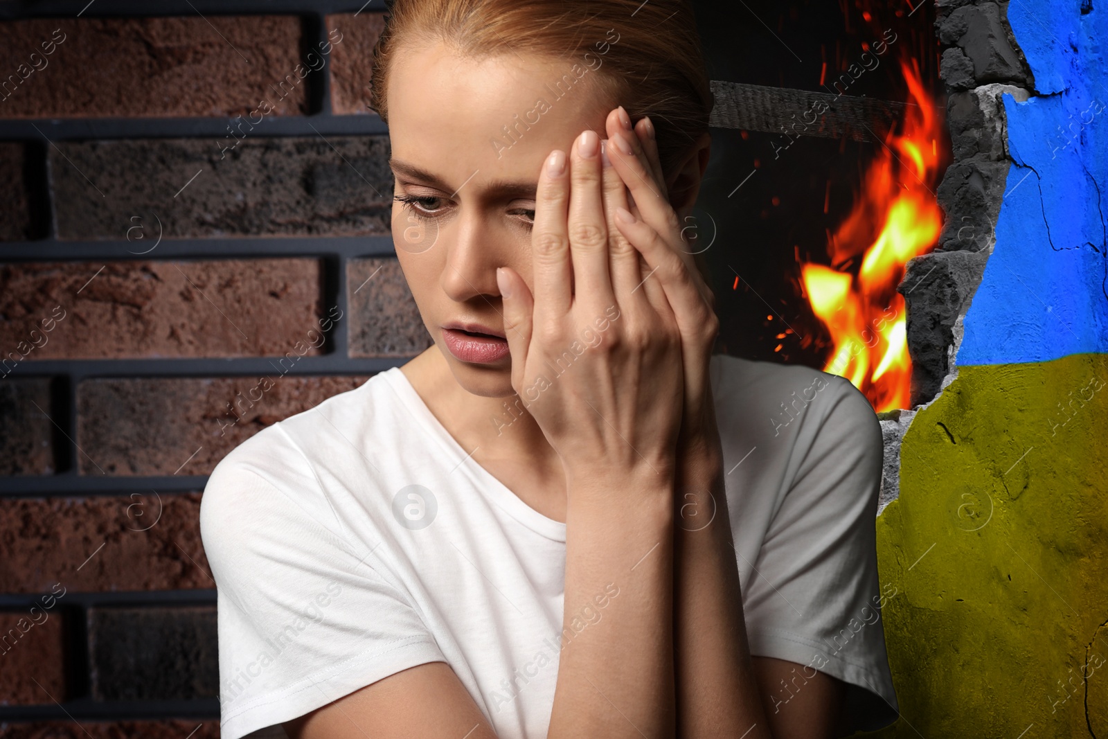 Image of Upset woman near wall of ruined building painted in color of national flag on fire. Stop war in Ukraine