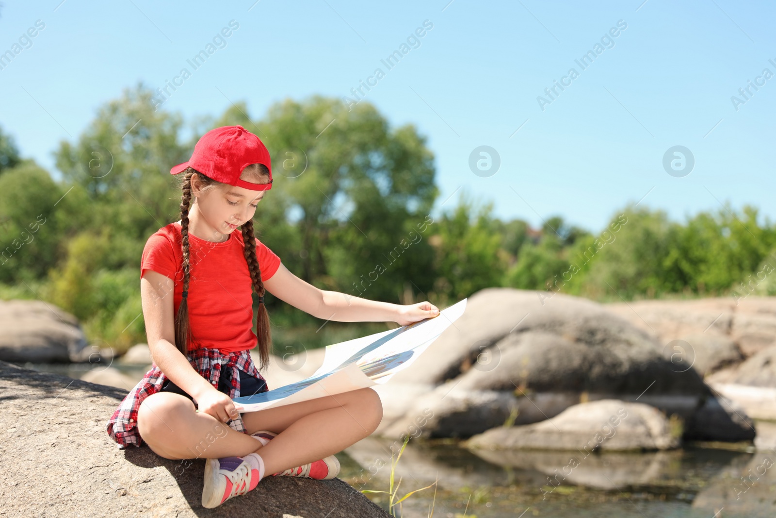 Photo of Little girl with map outdoors. Summer camp