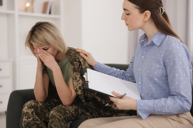 Psychotherapist working with military woman on sofa in office