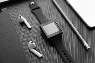 Photo of Composition with stylish smart watch on black table