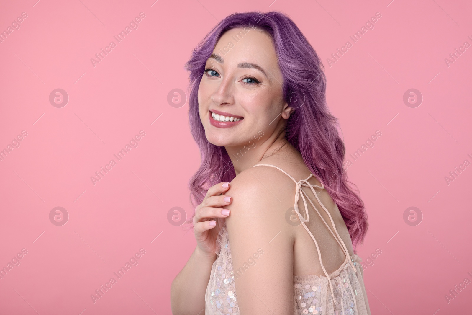 Image of Trendy hairstyle. Young woman with colorful dyed hair on pink background. Space for text