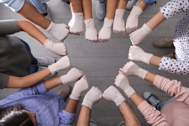 People in white medical gloves showing heart with hands indoors, top view
