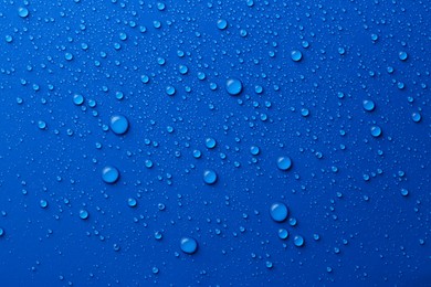 Water drops on blue background, top view