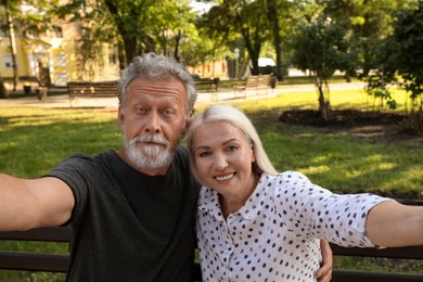 Photo of Lovely mature couple taking selfie in park