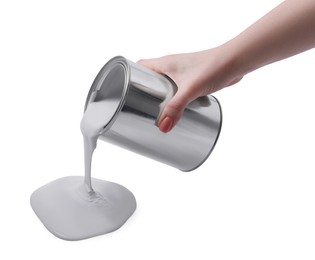 Photo of Woman pouring paint from can on white background, closeup