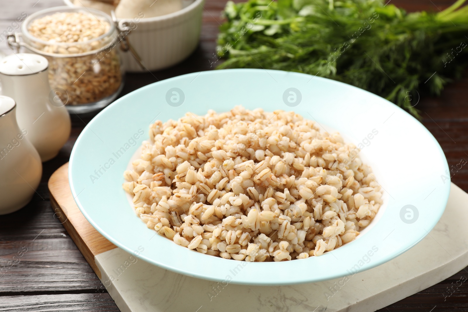 Photo of Delicious fresh pearl barley on wooden table, closeup