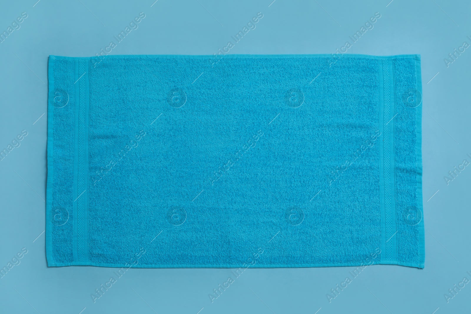 Photo of Soft beach towel on light blue background, top view