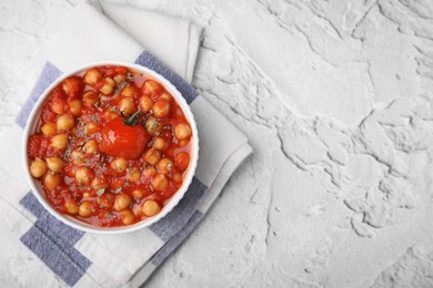 Delicious chickpea curry in bowl on white textured background, top view. Space for text