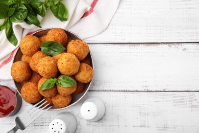 Photo of Bowl of delicious fried tofu balls with basil on white wooden table, flat lay. Space for text