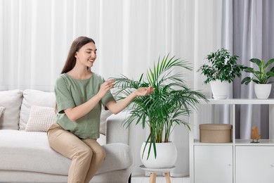 Photo of Beautiful young woman in room with green houseplants