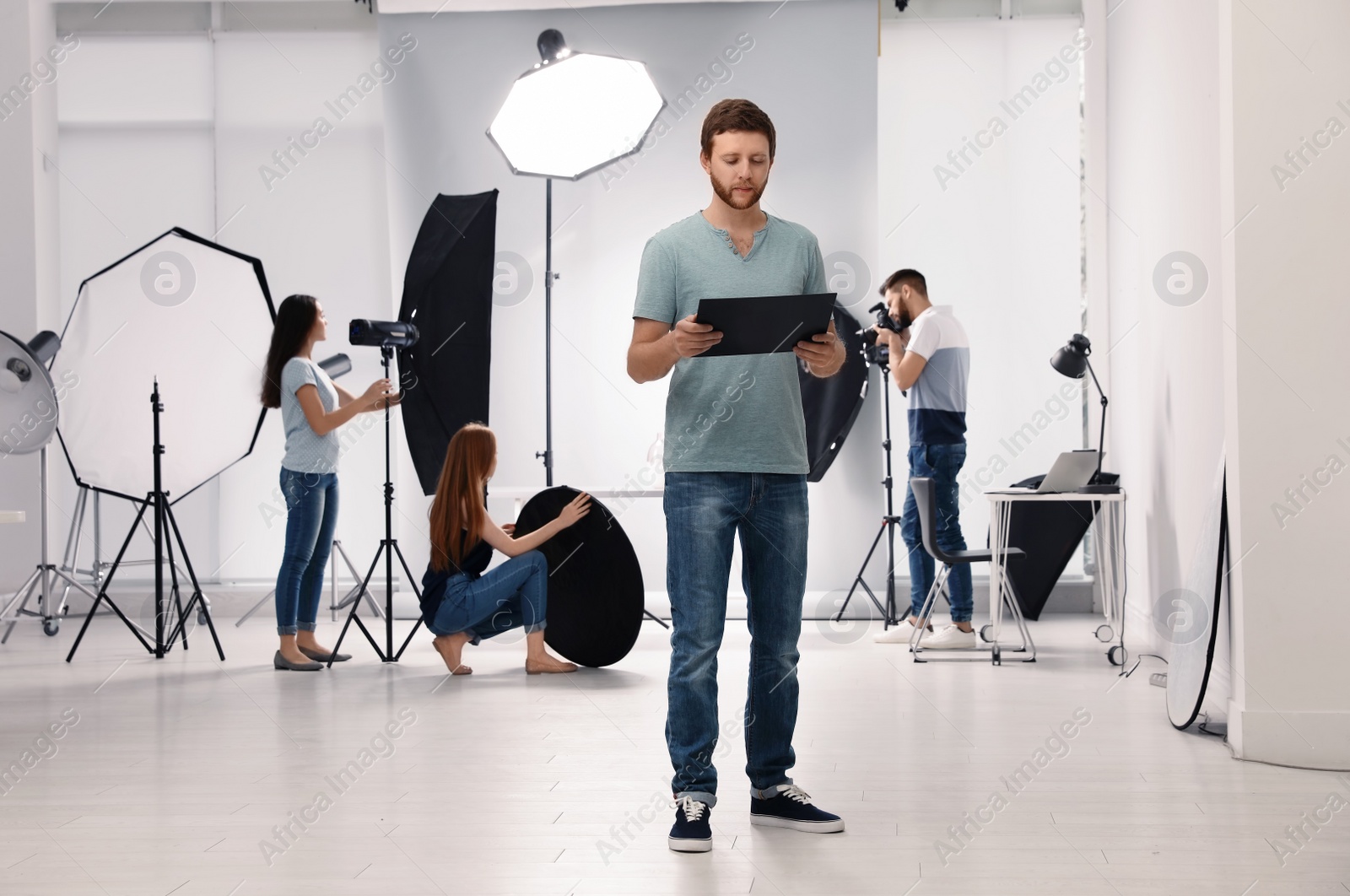 Photo of Photo studio with professional equipment and team of workers