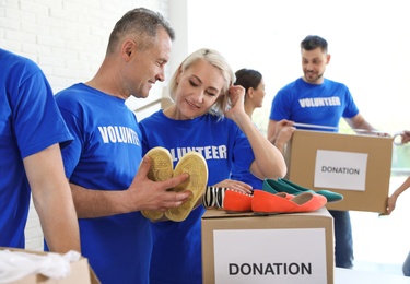 Team of volunteers collecting donations in boxes indoors