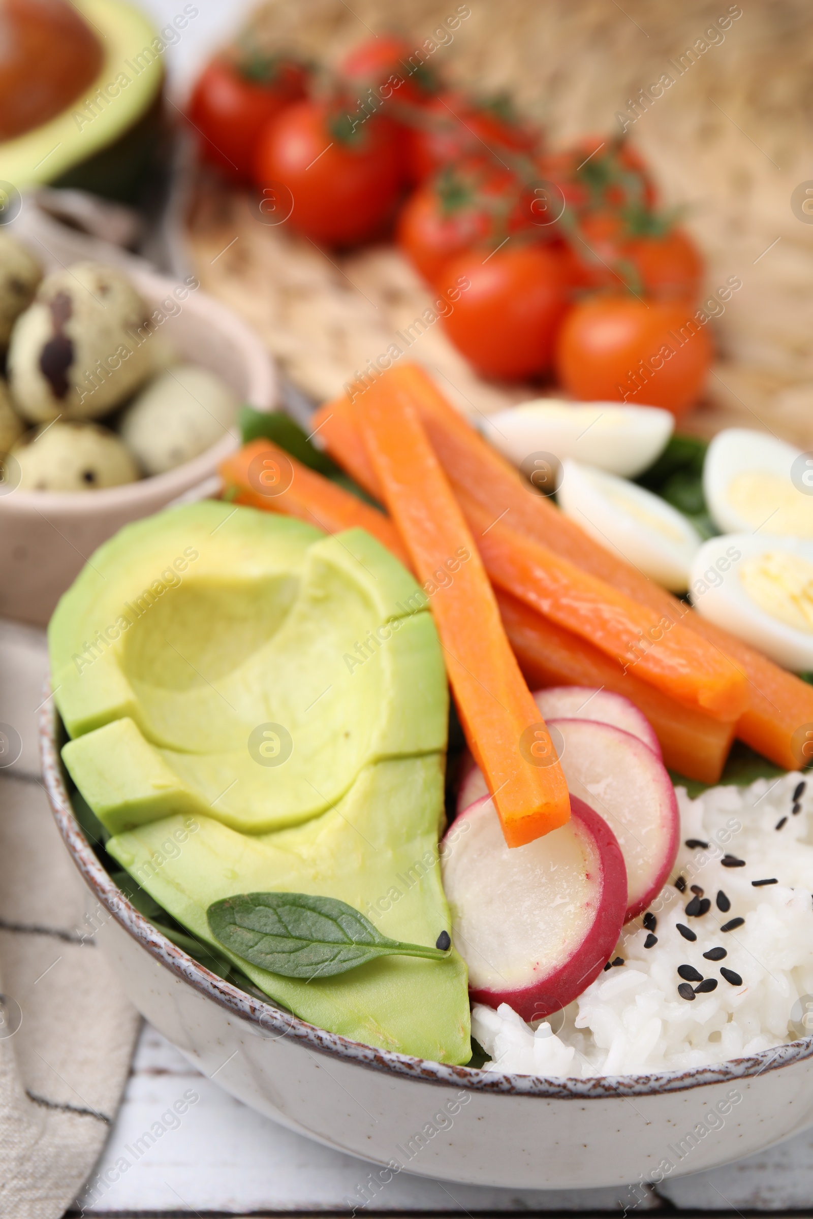 Photo of Delicious poke bowl with basil, eggs, avocado and vegetables on white wooden table, closeup