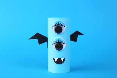 Photo of Spooky paper monster on light blue background. Handmade Halloween decoration