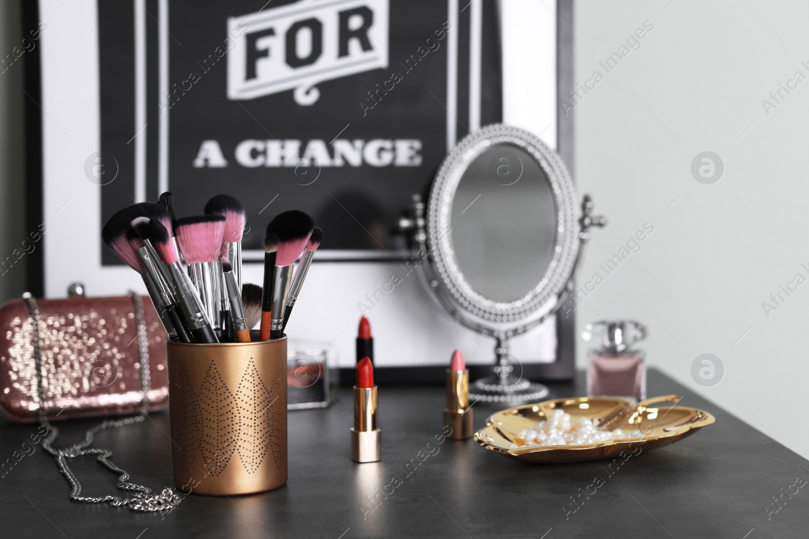 Photo of Makeup products and brushes on grey table