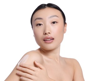 Beautiful young Asian woman with body cream smear on shoulder against white background