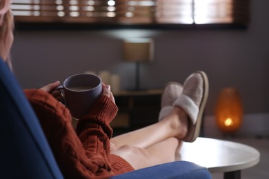 Photo of Woman with cup of aromatic coffee relaxing at home, closeup. Space for text