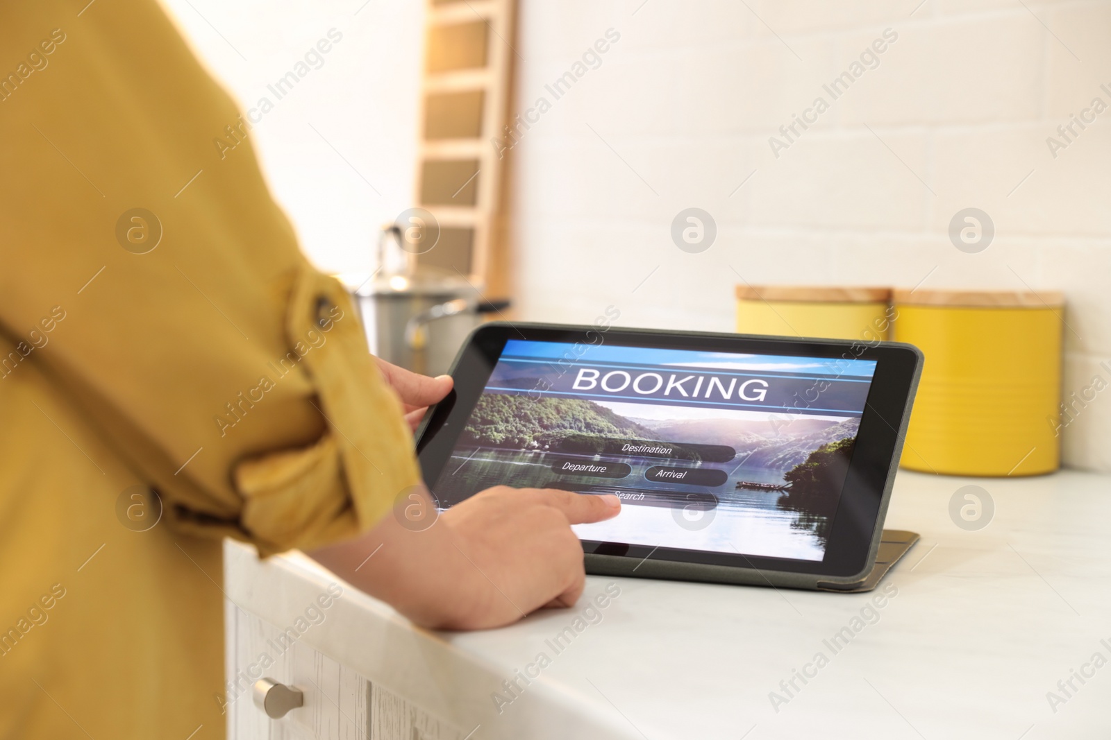 Photo of Young woman using tablet to plan trip indoors, closeup. Travel agency concept