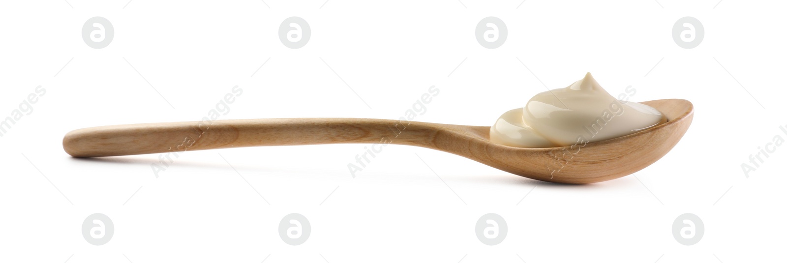 Photo of Natural yogurt in wooden spoon isolated on white