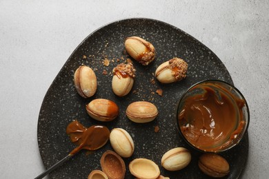 Photo of Delicious walnut shaped cookies with condensed milk on grey table, top view