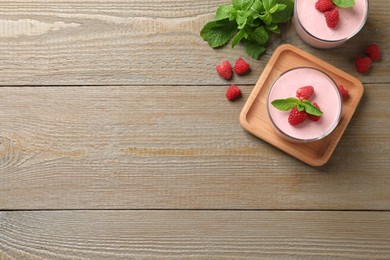 Photo of Delicious raspberry mousse with mint on wooden table, flat lay. Space for text