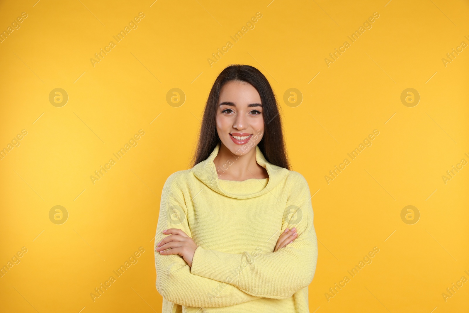 Photo of Beautiful young woman wearing warm sweater on yellow background