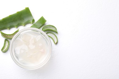 Photo of Aloe vera gel and slices of plant on white background, flat lay. Space for text