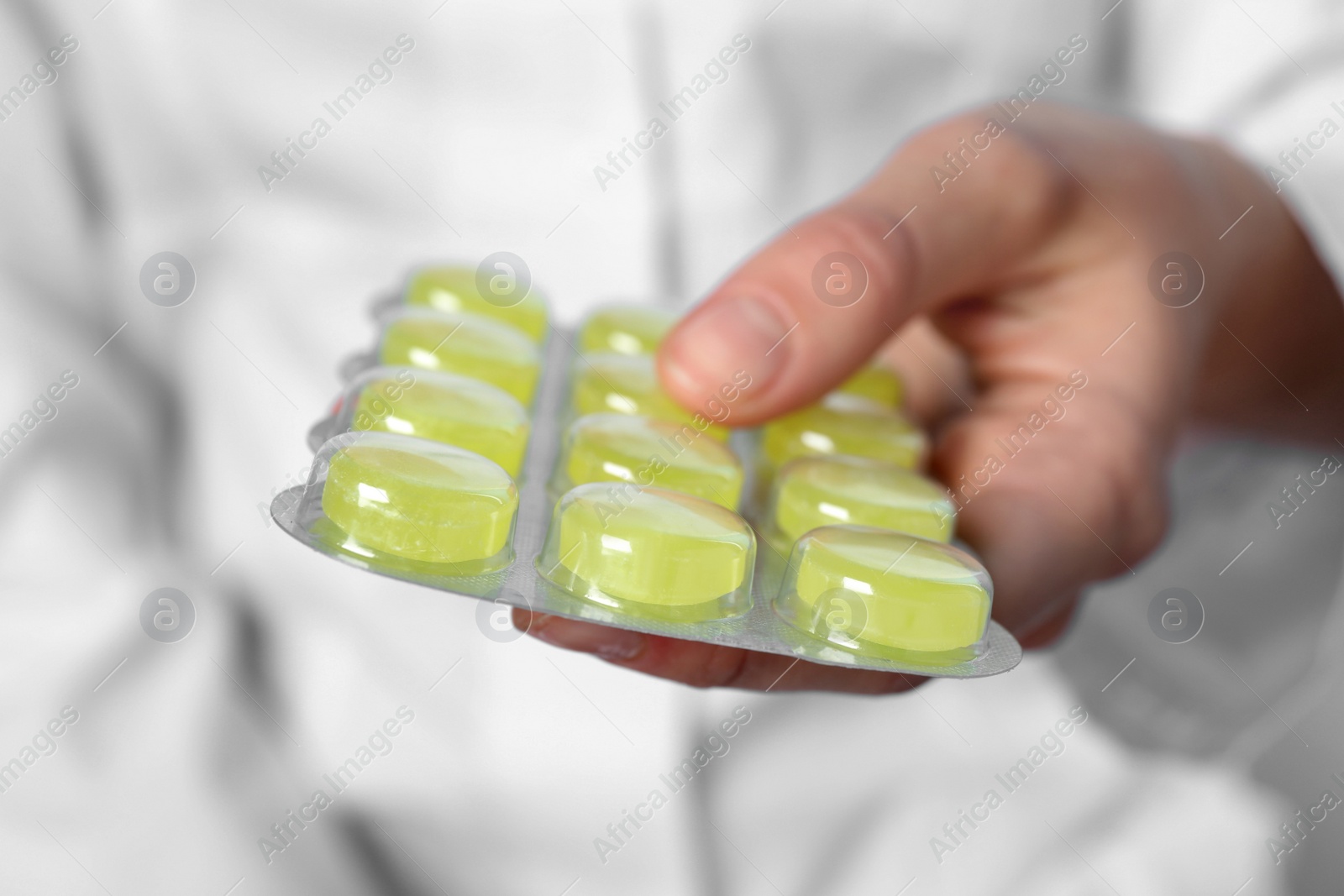 Photo of Woman holding blister with cough drops, closeup