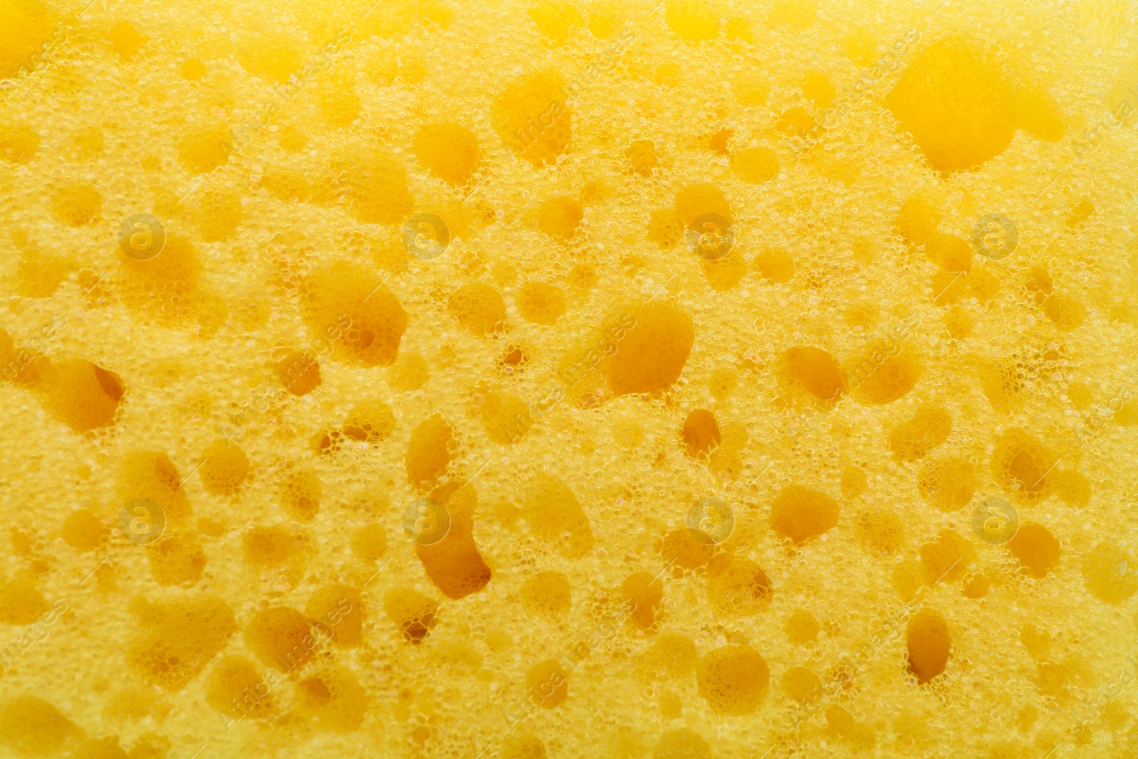 Photo of Yellow cleaning sponge as background, top view