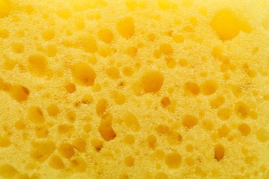 Yellow cleaning sponge as background, top view