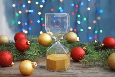 Photo of Hourglass and festive decor on table. Christmas countdown