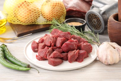 Pieces of beef and products on white wooden table