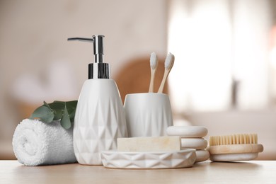 Image of Bath accessories. Different personal care products and eucalyptus leaves on wooden table in bathroom