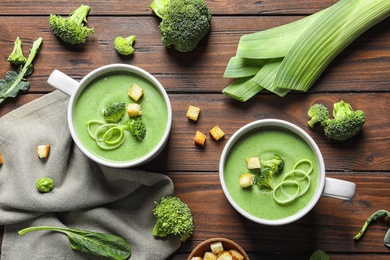 Fresh vegetable detox soup made of broccoli served on wooden table, top view