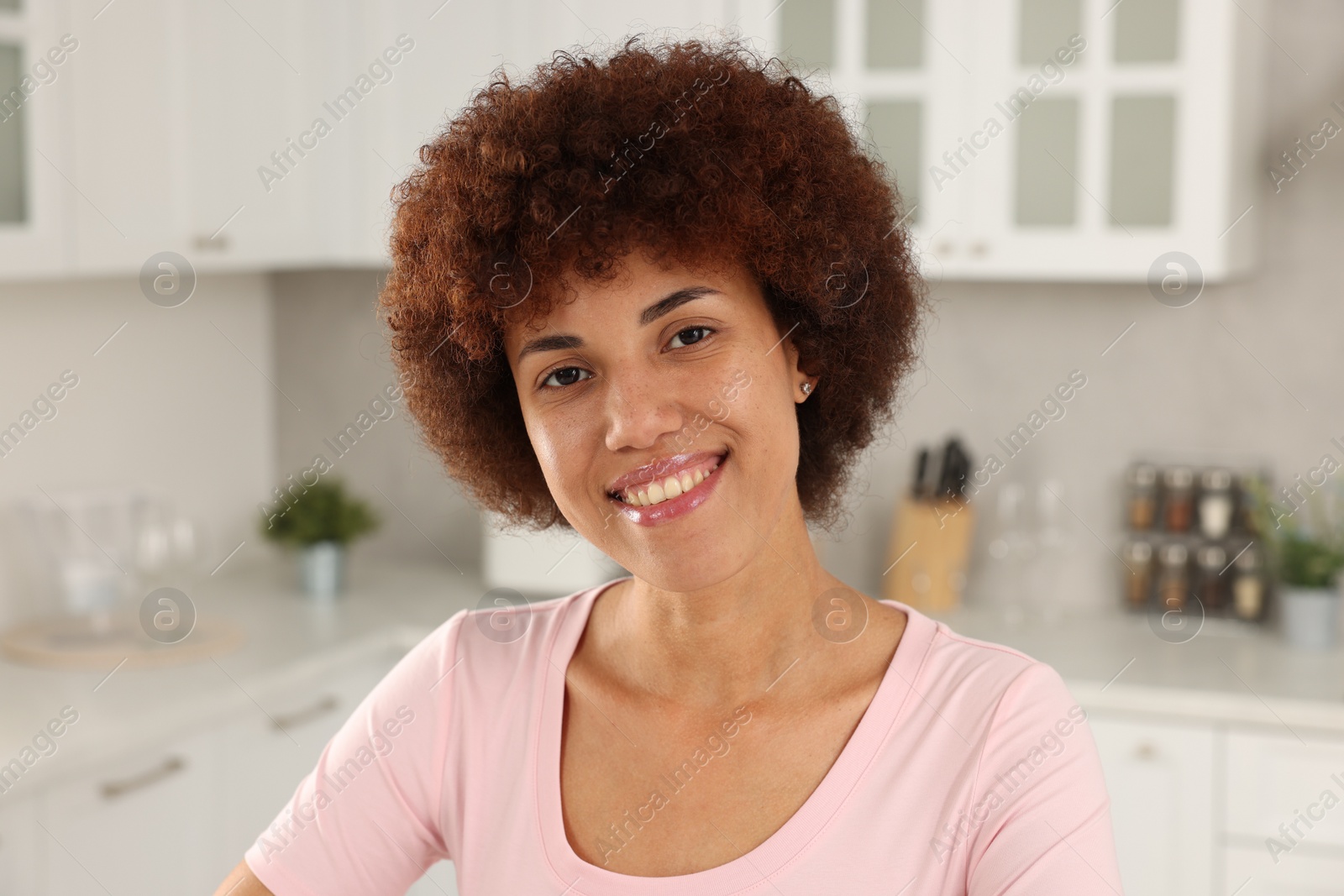 Photo of Portrait of happy young woman in kitchen