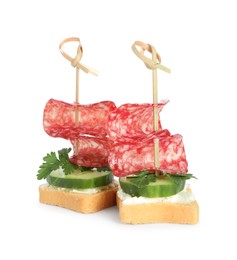 Photo of Tasty canapes with salami, cucumber and cream cheese isolated on white