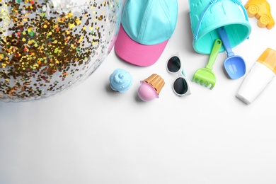 Composition with bright beach toys on white background, top view