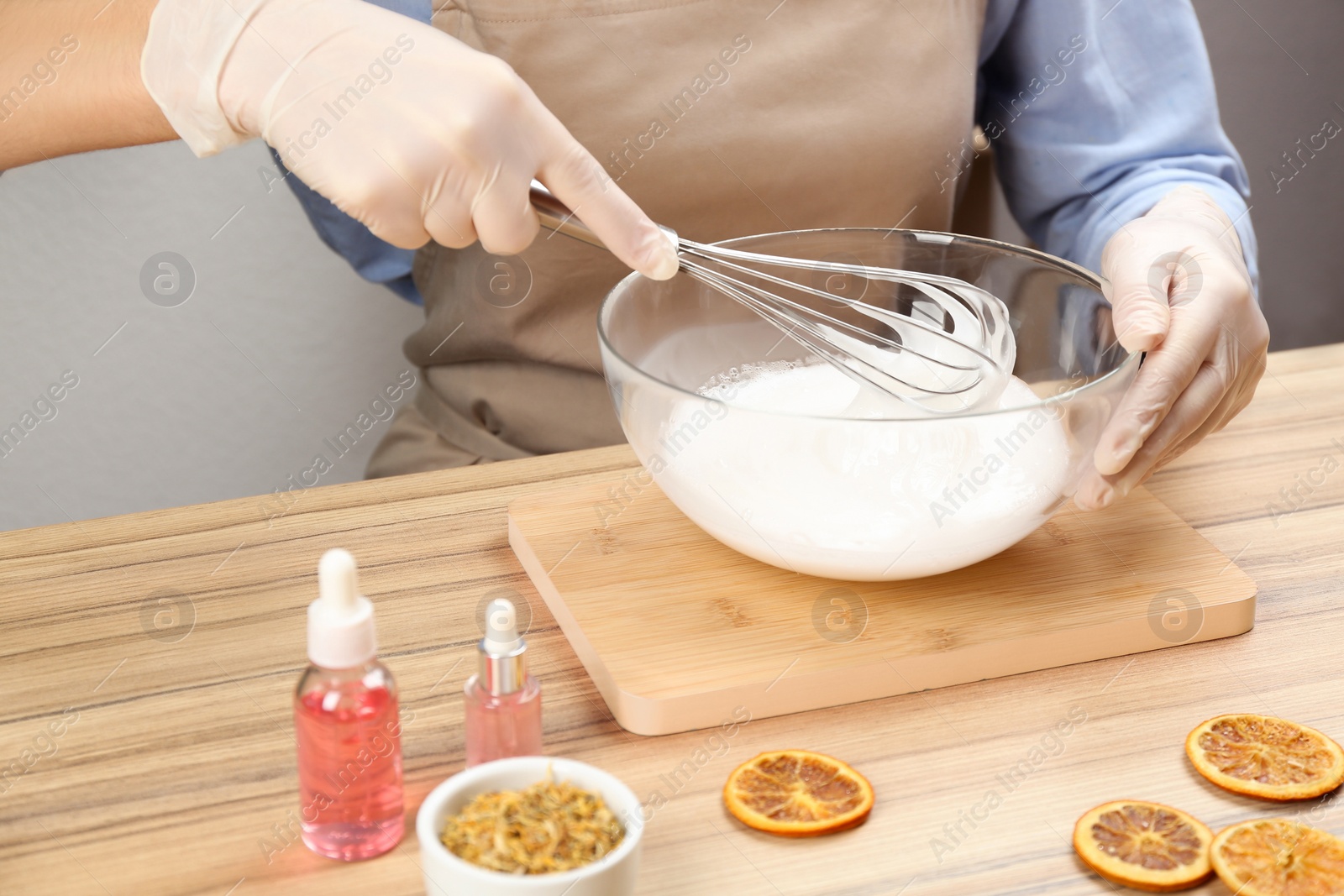 Photo of Woman making natural handmade soap at wooden table, closeup