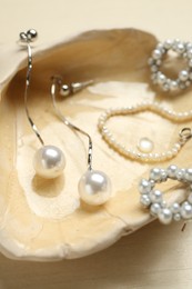 Photo of Beautiful seashell with luxury jewelry on wooden background, closeup