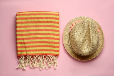 Photo of Beach towel and straw hat on pink background, flat lay