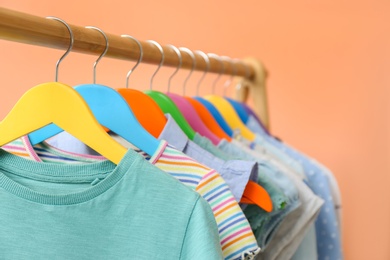 Photo of Rack with stylish children clothes on beige background, closeup. Space for text