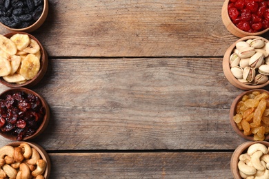 Photo of Composition of different dried fruits and nuts on wooden background, top view. Space for text