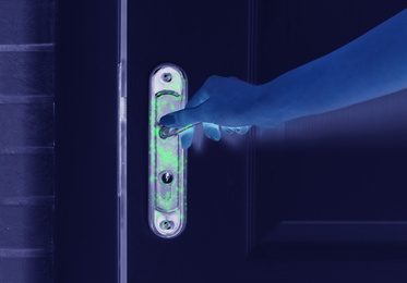 Man opening door, closeup view under UV light. Avoid touching surfaces in public spaces during coronavirus outbreak