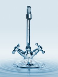 Image of Water dripping from tap with splash on light background